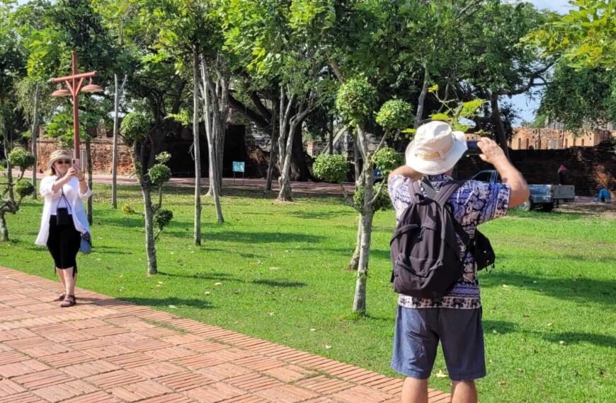 Na pierwszym planie mężczyzna robi zdjęcie zabytkom, na drugim planie kobieta, która robi zdjęcie mężczyźnie,