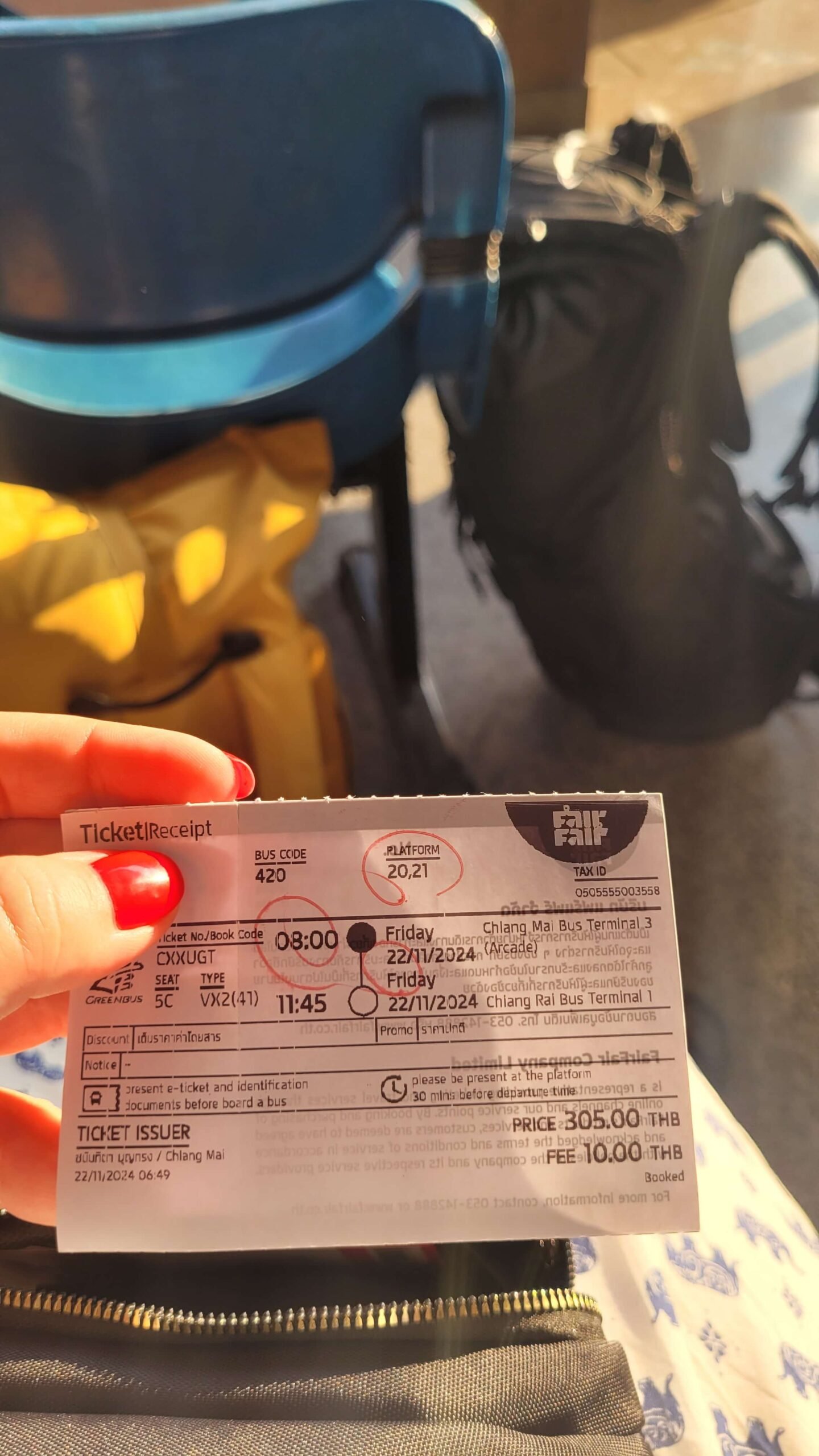 Na zdjęciu widoczny jest bilet autobusowy pomiędzy Chiang Mai a Chiang Rai z zakreśloną datą i godziną odjazdu. Widnieje cena 305 THB i opłaty 10 THB.